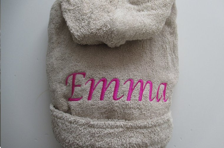 Badjas kleur zand met naam op rug geborduurd. Maat 0-12 maand