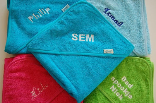 Gepersonaliseerde baby badcape met naam en afbeelding van een kroontje geborduurd